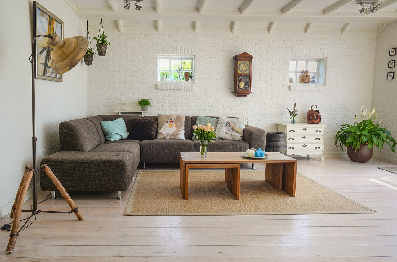 Moderne kamer met greige bank en kleurrijk tapijt.