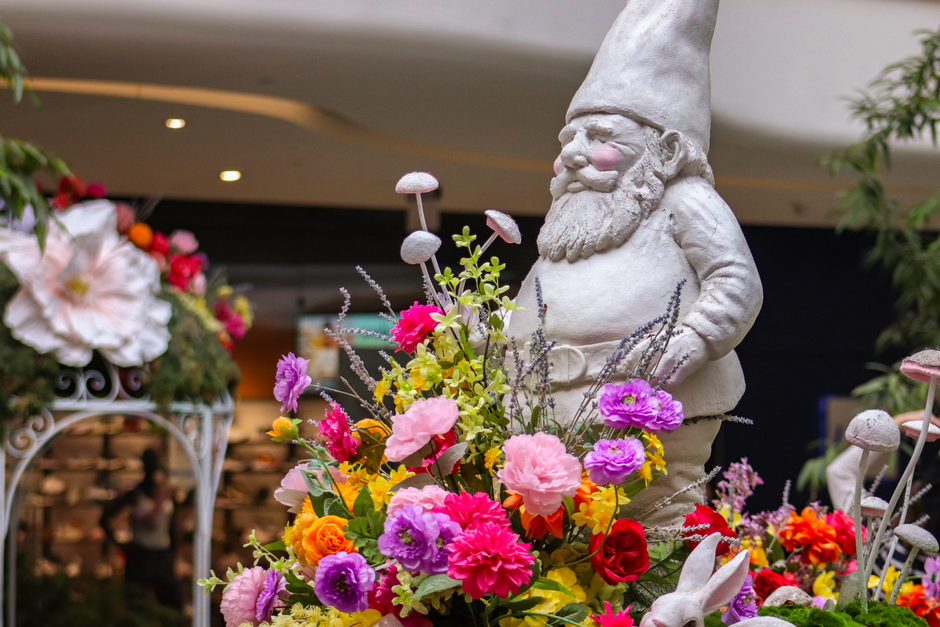 Kabouterbeeldjes tussen kleurrijke zomerbloemen.