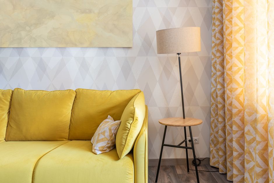 Okergele bank met olijfgroene kussens in herfstinterieur. Okergele bank met olijfgroene kussens in herfstinterieur.